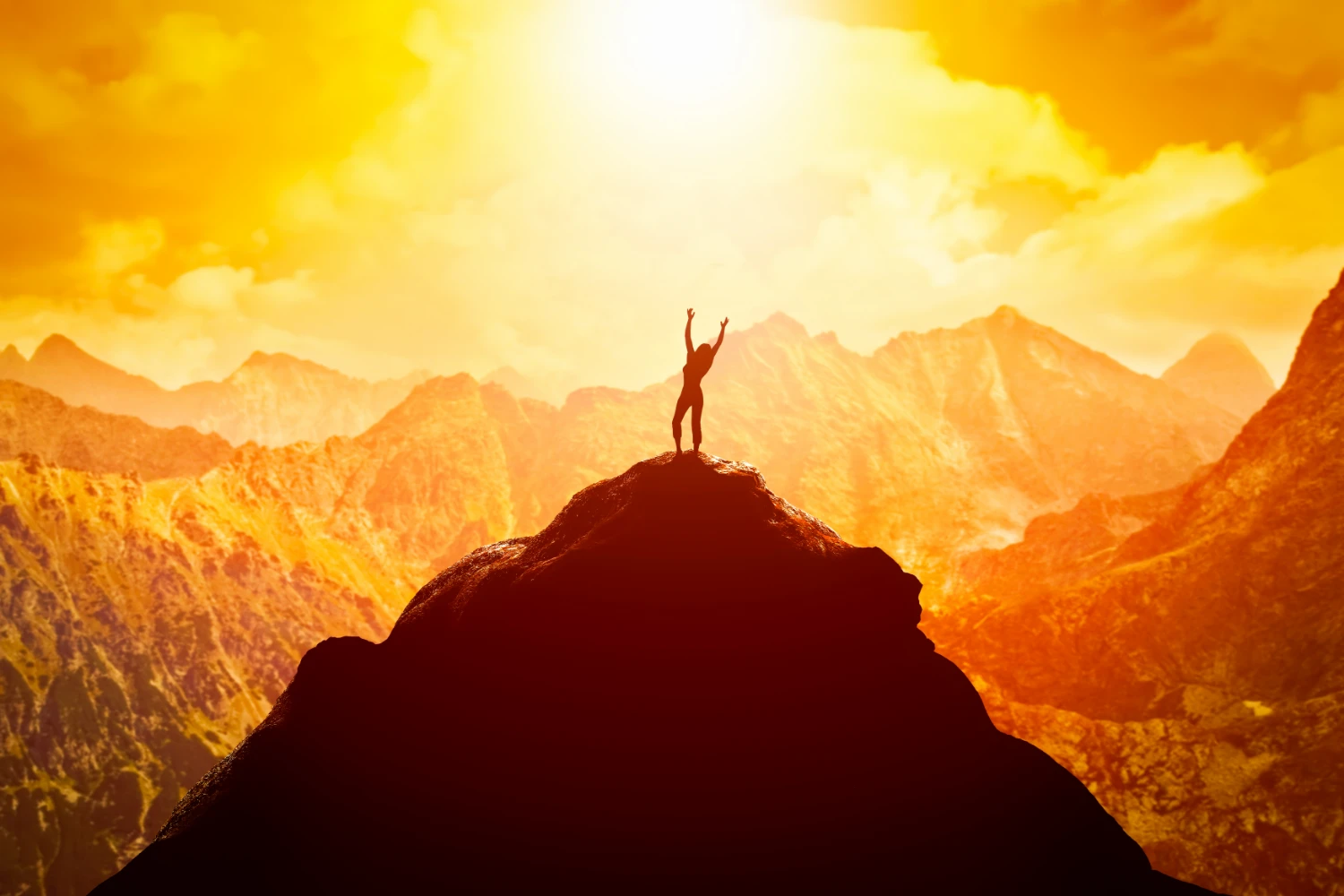 فردی که بر روی قعله کوه ایستاده است و دستان خود را به نشانه موفقیت باز کرده و خورشید از پشت به آن میتابد
