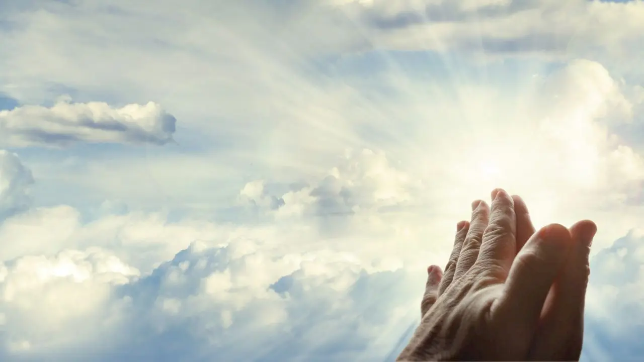 دستانی که به هم چسیبده اند و به سمت آسمان و خورشید گرفته شده است