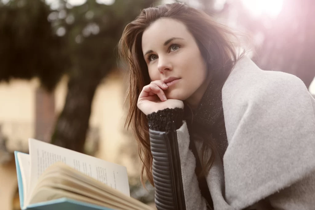 زنی که درحال کتاب خواندن میباشد و توجهش جلب چیزی دیگری شده است و سرش را به سمت راست چرخانده است