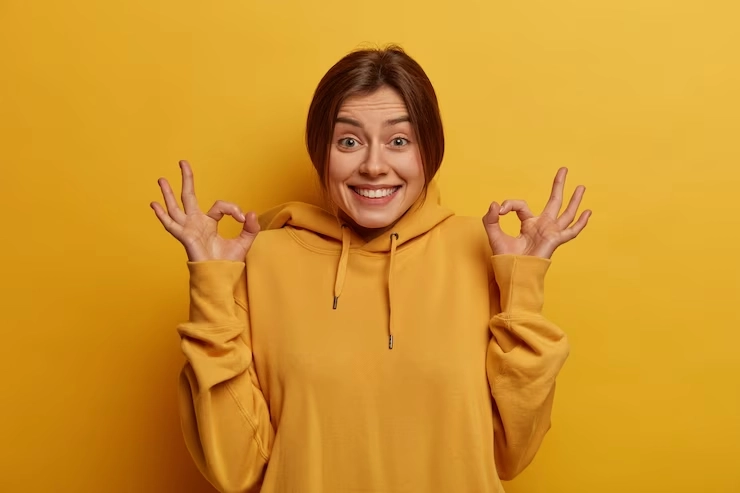 آدم منفی - تصویر دختری با لباس و زمینه زرد و حالت شاد و انرژی مثبت