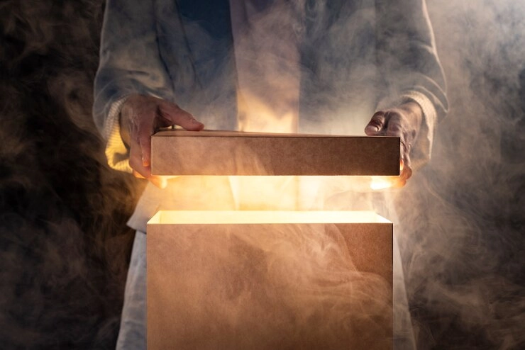 تصویر یک صندوق پر از نور در حال باز شدن به دست یک شخص